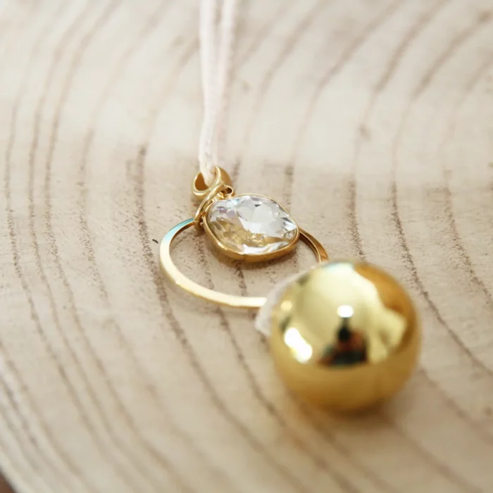 gros plan sur pendentif en strass et plaqué or de votre bopla de grossesse